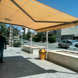 سایبان تراس بازویی با پوشش مقاوم در فضای بیرونی