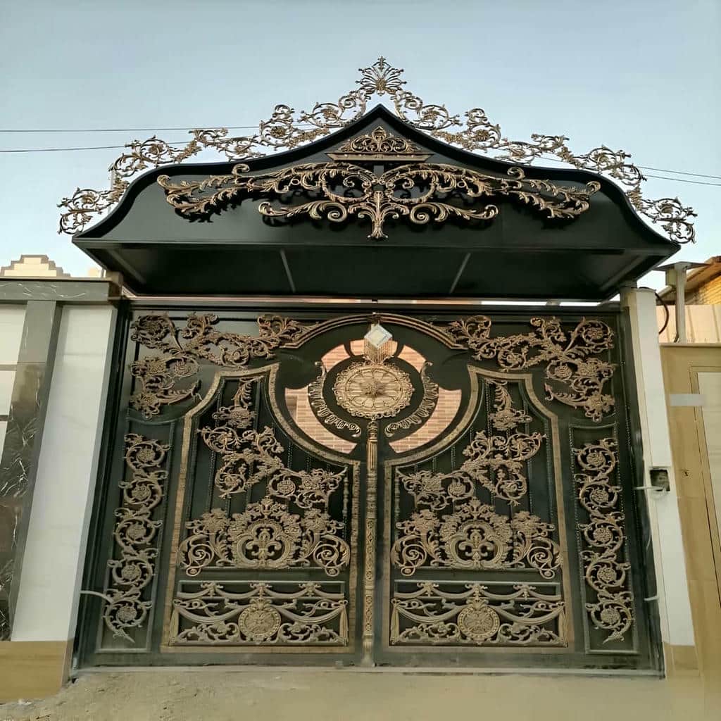 درب حیاط فرفورژه نصب شده کنار نمای سنگی یزد