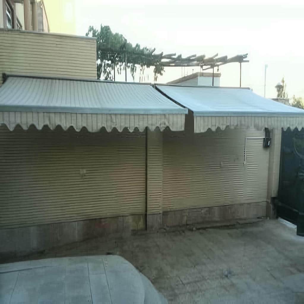 سایبان برقی پارچه ای کنار نمای آجری