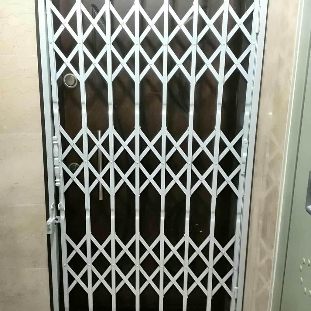گارد آکاردئونی سفید کنار ورودی آپارتمان